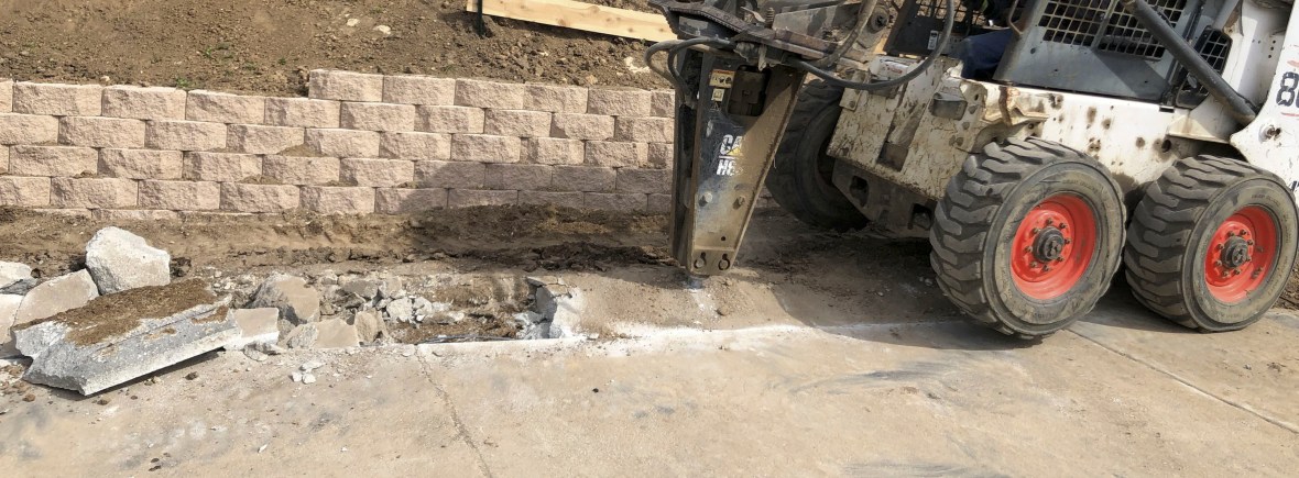 Concrete removal project in progress with bobcat tractor